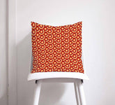 Orange cushion throw pillow with 70s retro circles design featuring concentric circles in red and orange shades
