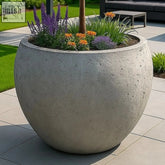 Orbello onyx dusk 110cm xxl round planter made of pigmented cement stone with vibrant purple and orange flowers