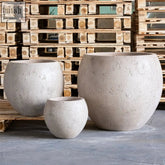 Three round textured concrete planters in varying sizes featuring orbello 55cm planter for outdoor plants