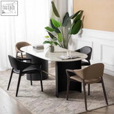 Modern oval dining table with polished white marble top and sleek black legs by nīsu home with wooden frame