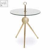 Oria clear glass gold frame side table with a gold-toned tripod base and clear glass top featuring a spherical center base