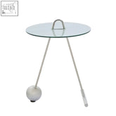 Oria end table with glass top, slender stainless steel legs, and a shiny spherical base for modern living spaces