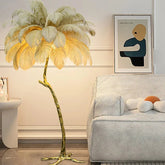 Golden ostrich feather floor lamp with curved metallic stem and glowing feathery canopy for living room lighting