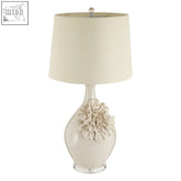 Cream-colored padma table lamp with acrylic base and sculpted floral accent and matching drum shade