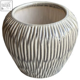 A small fleck vase made of matte gray ribbed ceramic with subtle vertical grooves perfect for plants or decor