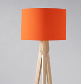 Vibrant orange lampshade with cylindrical design on a light wood tripod base perfect for table lamp use