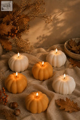 Six lit pumpkin shaped candles in warm orange and creamy white wax with a smooth glossy finish perfect for pumpkin spice decor