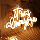 A glowing qiaofei led neon sign with it was always you in warm white cursive script with dimmer switch for decor