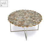 Rabia agate coffee table with cross base featuring a round mosaic top of polished earthy agate slices and sleek chrome legs