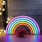 A vibrant rainbow led neon sign with smooth curves and multicolored glow for indoor home party decor
