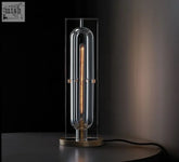 Raito Light sleek modern table lamp with clear glass and illuminated edison-style filament bulb in brushed brass finish