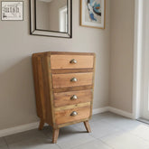 A rustic recycled teak wood chest of drawers with four light weathered fronts and metal handles for storage