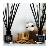 Black glass reed diffuser set with black reed sticks and white dank mer logo labels for home fragrance