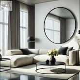 Cream-colored sectional sofa with black pillows next to a sleek 120cm rei round wall mirror with black metal frame
