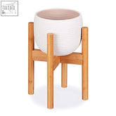 White ribbed ceramic flower pot resting on a natural relaxdays bamboo plant stand with adjustable height