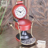 Red and brass miniature retro barber clock shaped like a hairdressing chair with white face and black numerals
