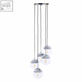 Chrome finish five pendant lights with spherical glass globes suspended by thin cables for modern lighting