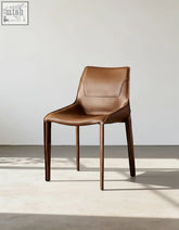 Rinaldi modern dining chair in brown real leather with sleek design and tapered wooden legs for dining room use