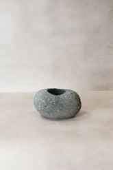 A smooth rounded gray stone planter pot with natural texture and dark interior called river stone planter pot no12