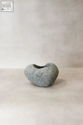 A smooth gray handmade riverstone planter pot no6 with a rounded shape and hollowed-out center for plants