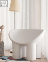 A sleek white roly poly fiberglass armchair with thick legs and curved seat perfect as a dressing table chair