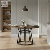 Round modern walnut dining table with architectural black metal pedestal base and parquet top for stylish walnut dining