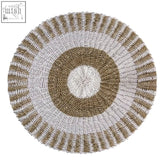 Round seagrass placemat with beige and off-white concentric rings made from natural fiber perfect for sunlit tables