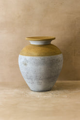 Rustic indonesian pot no 15 is a rustic indonesian ceramic vase with golden yellow top and weathered gray rounded body