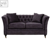 Dark purple velvet sofa with rolled arms and tufted design matching throw pillows in sabrina grey velvet sofa style