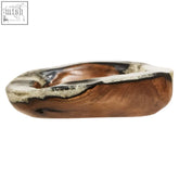 A rustic oval sakra teak resin bowl with natural wood grain finish and darkened edges, used as a black decorative bowl