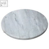 A white marble round chopping and serving board with light gray veining and a smooth polished surface