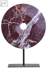 A salmo small red marble round disc sculpture with deep burgundy and white veining on a black metal stand