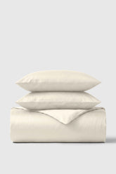 Cream-colored soft textured cotton sateen duvet cover set with matching pillows for cozy bedroom style