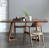 Modern walnut shoko dining table with sleek angular legs and smooth warm wood finish perfect for dining spaces