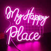 A glowing pink led neon light with cursive happy place text on acrylic for wall decoration in bedroom or game room