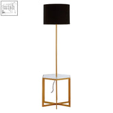 Gold floor lamp with black cylindrical shade on a white marble hexagonal glass-top side table base