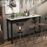 Black metal frame bar table with white sintered stone top and three stools with wooden seats and chrome bases