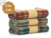 Three rolled small checked random recycled wool blankets in colorful plaid with earthy tones and textured weave