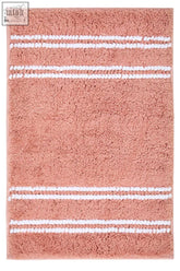 A plush dusky pink bath mat with three white woven stripes perfect for adding cozy style to your bathroom