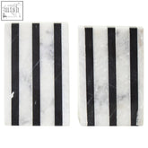 Black and white marble coasters with vertical stripes paired with white marble bookends for a stylish desk look