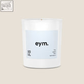 A minimalist white glass standard candle jar with a light blue eym label and soul scent in black text