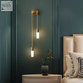 Modern brass wall light with two frosted glass shades featuring warm white led wall illumination
