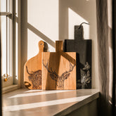 Natural wood stag prince oak paddle cutting board with detailed engraved deer head design medium size