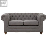 Gray tufted two seat grey linen chesterfield sofa with rolled arms and wooden legs perfect for cozy living rooms