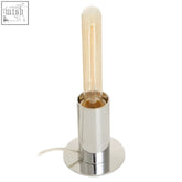 A stockholm chrome finish table lamp with a polished chrome base and an exposed edison-style warm amber bulb
