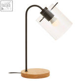 Stockholm matte black curved table lamp with frosted glass shade wooden base and black metal arm on desk