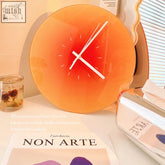A vibrant gradient orange sunset clock with minimalist white hands and markers for modern wall decor