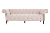 A blush pink tufted velvet blossom fabric chesterfield sofa with rolled arms and larch wood legs