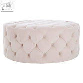 Cream-colored tufted velvet suri footstool with round cushioned design and sturdy larch wood frame