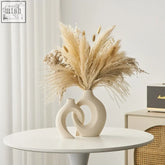 Cream-colored ceramic vase Suzuki vase with sculptural design featuring interlocking curves perfect for dried arrangements